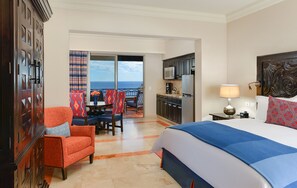 Enjoy ocean views from the comfort of this spacious room, featuring a large bed, seating area, and kitchenette.