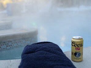A can of Coors Banquet beer next to a pool with a blue towel.