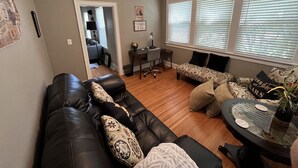 A living room with a black leather sofa, a patterned armchair, and a small round table with a vase. - “New” Elizabethtown Poplar Place! (Elizabethtown)