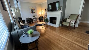 A living room with a fireplace, a television, and a dining area with a table and chairs. - “New” Elizabethtown Poplar Place! (Elizabethtown)