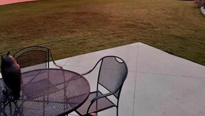 A patio with a table and chairs overlooking a lake during sunset. - Soothe Your Soul Lakeside on Beautiful Lake Balboa (Hot Springs Village)