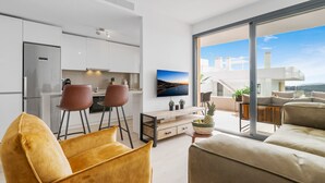 Een modern appartement met een keuken, een eethoek en een woonkamer met een groot raam.