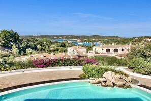Una piscina con vista chiara sul paesaggio circostante, con edifici e alberi.