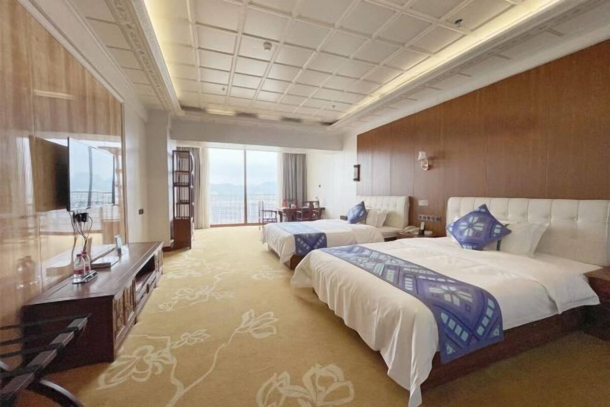 Ett hotellrum med två sängar, en TV, ett skrivbord och utsikt över omgivningarna.