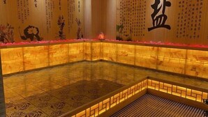 Un onsen japonais traditionnel, avec des sols carrelés et un mur en bois orné de calligraphies.