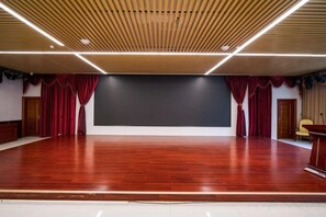 An indoor space with a stage, curtains, and a podium. - Gujiang Hotel (Dahua)
