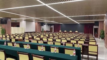 A conference room with rows of chairs and tables, equipped with nameplates and water bottles.