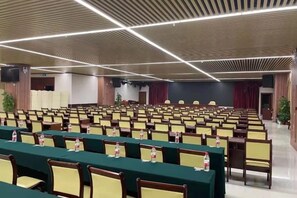 A conference room with rows of chairs and tables, equipped with nameplates and water bottles. - Gujiang Hotel (Dahua)