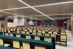 A conference room with rows of chairs and tables, equipped with nameplates and water bottles.