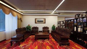 Una habitación con alfombra estampada, muebles de madera y una estantería.