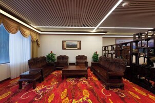 Una habitación con alfombra estampada, muebles de madera y una estantería.