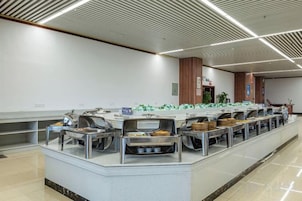 Montaje tipo buffet con varias estaciones de servicio y una larga barra.