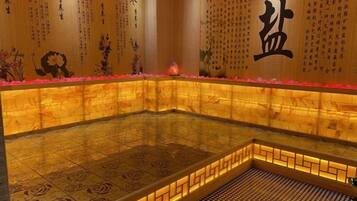 A traditional Japanese onsen with a tiled floor, wooden walls, and a tiled ceiling.