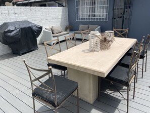 Enjoy dining al fresco at this outdoor patio, complete with a sturdy table and six comfortable chairs.