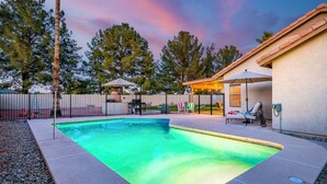 A backyard with a swimming pool, outdoor furniture, and a covered patio area. - Arrowhead Family Getaway Pool Pet Friendly (Peoria)