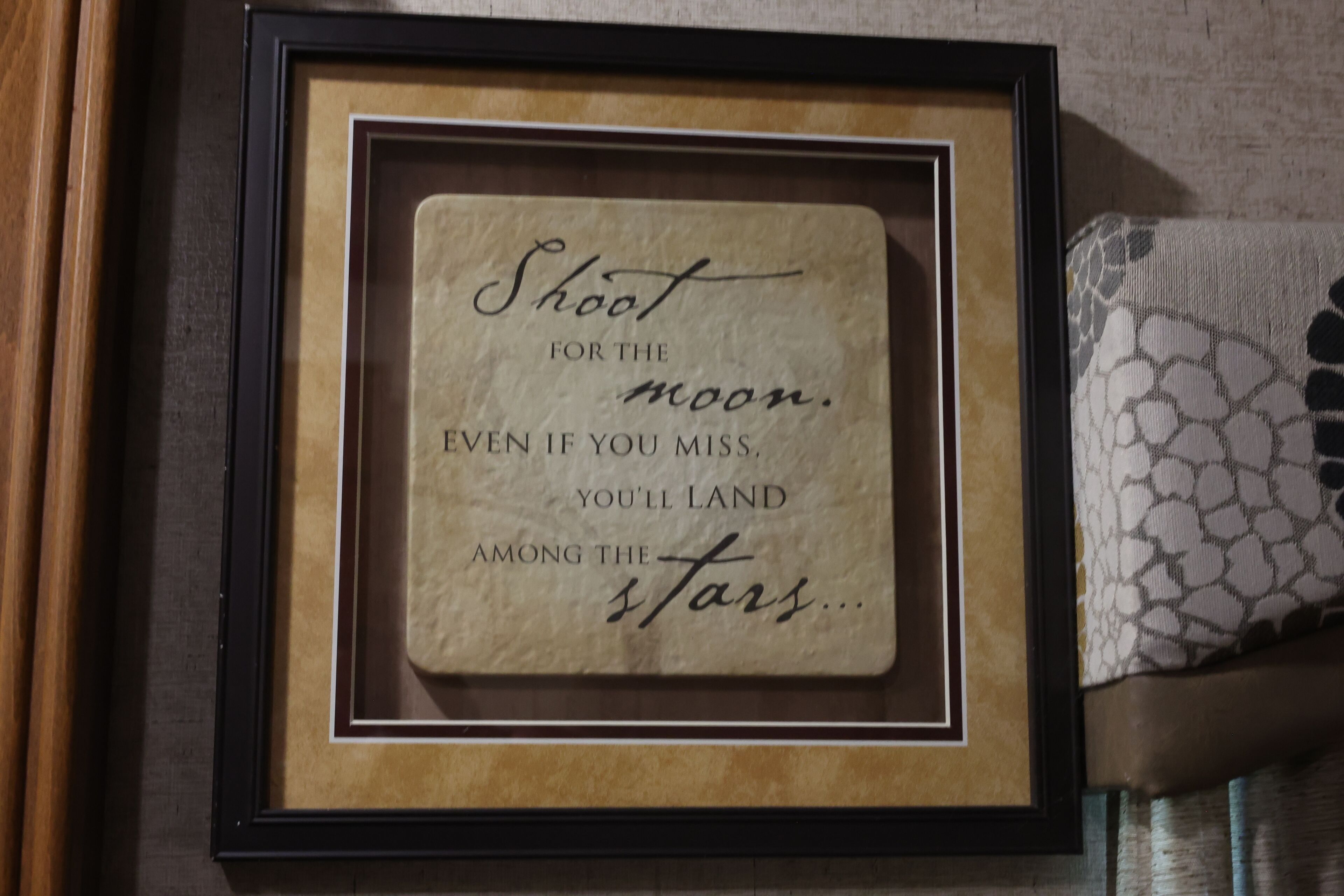A framed inspirational quote on a wall.