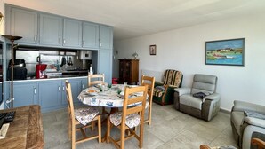 A compact living space with a dining area, kitchen, and seating area.