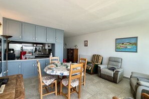 A compact living space with a dining area, kitchen, and seating area. - Appt Avec vue Exceptionnelle sur la Baie + Garage (Le Crotoy)