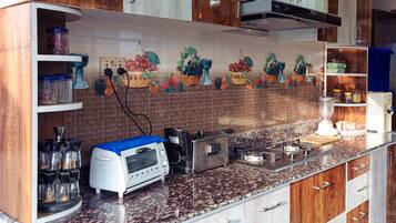 Una cocina con armarios de madera, microondas integrado y salpicadero de azulejos.