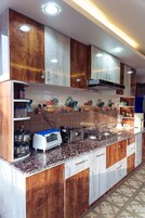 Una cocina con armarios de madera, microondas integrado y salpicadero de azulejos.