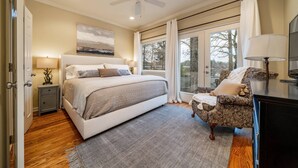 A bedroom with a bed, a chair, a desk, a ceiling fan, and a window with curtains. - Moonlight Baydream: Lakefront Home w/ Private Dock, Large Patio, Fast WiFi & Near Oaklawn & Downtown (Hot Springs)