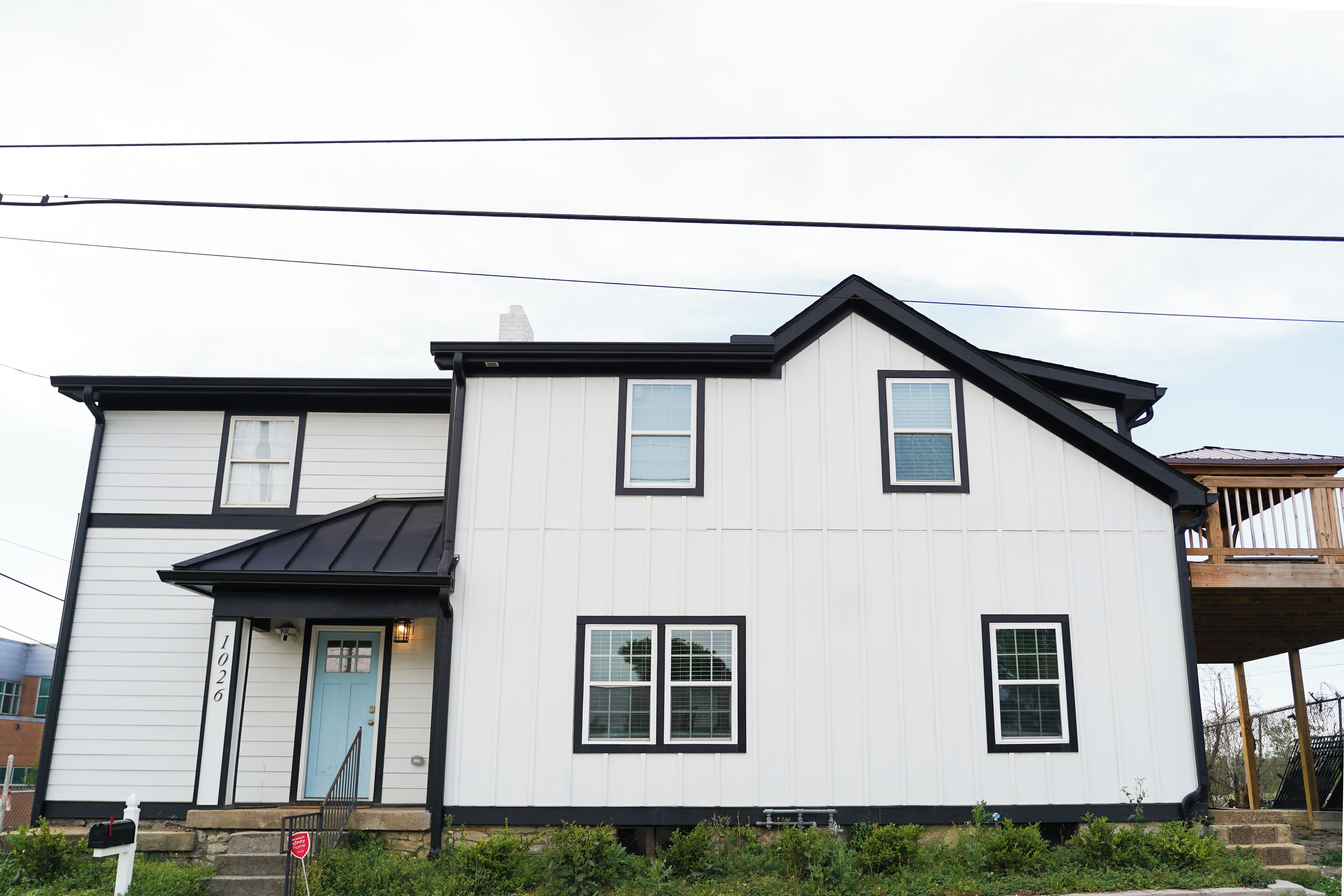 A two-story house with a white exterior and black trim.