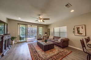 A spacious living room with a large window, a ceiling fan, and a fireplace. - Rio Rancho Guadalupe Rg 206 3 Bedroom Condo by RedAwning (New Braunfels)
