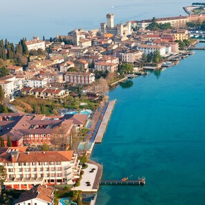 Un pueblo costero con edificios históricos, un puerto deportivo y un castillo destacado.