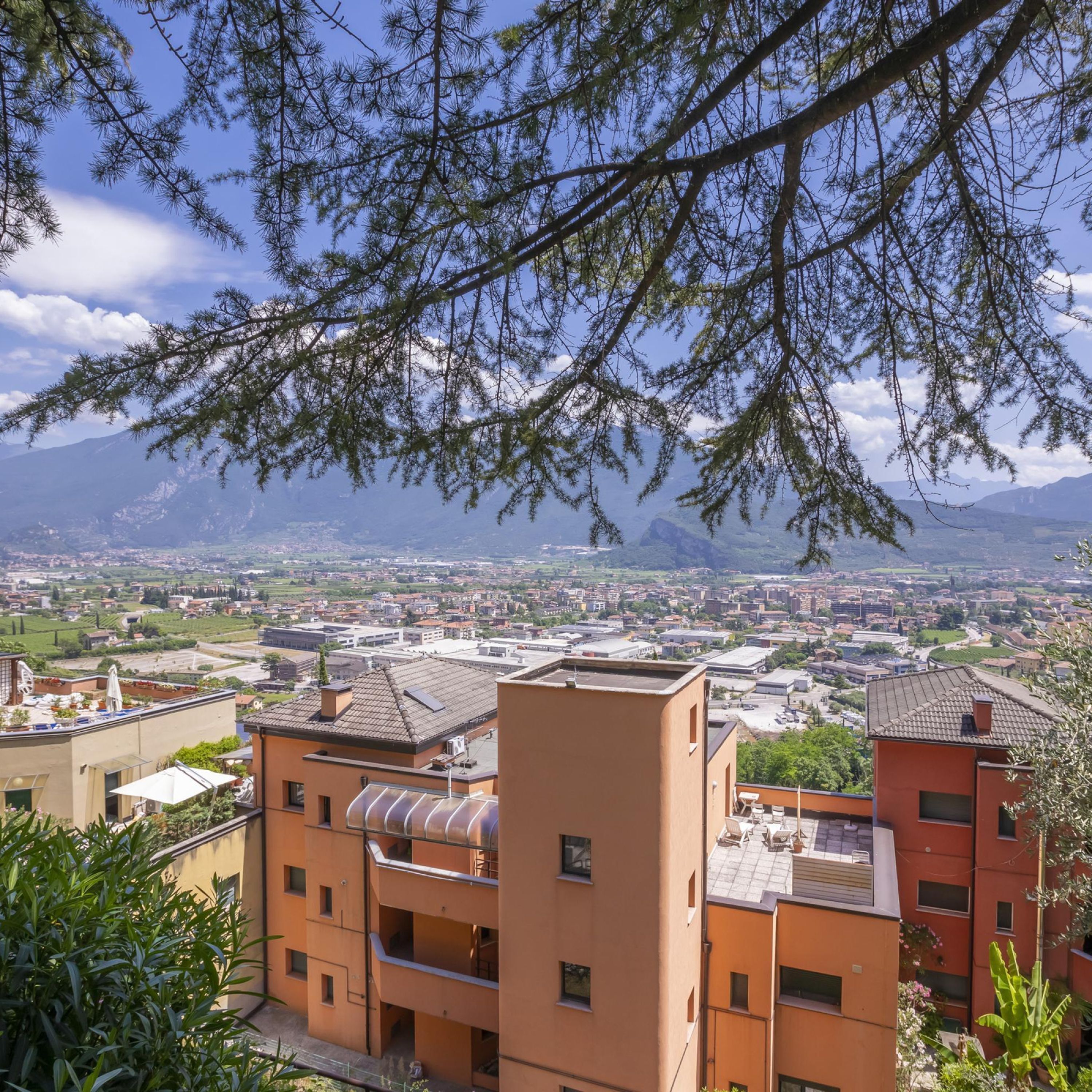 Un quartier résidentiel avec des bâtiments modernes, un ciel dégagé et des montagnes à l’horizon.