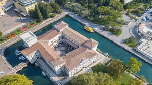 An aerial view of a historic building with a central courtyard, surrounded by water and greenery. - Paulie Apartment in Riva del Garda (Riva del Garda)