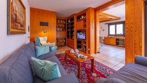 Uma sala de estar com sofá, mesa de centro e estante.