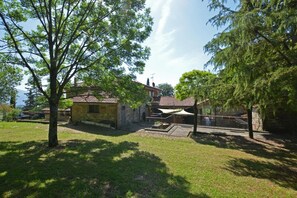 Relax in a serene outdoor setting surrounded by lush greenery and a traditional stone building.