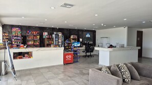 A modern hotel lobby with a reception desk, a seating area, and a vending machine. - Casa Blanca C 302 · Comfy and Relaxing Sea View (Puerto Peñasco)