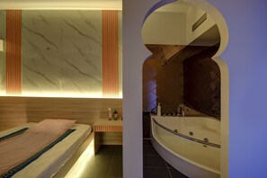 A modern bathroom with a large bathtub, a wooden vanity, and a marble-patterned wall. - Wescott Hotel (Dubai)