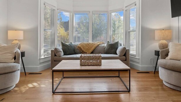 Un salón con sofá, una mesa de centro y una ventana con persianas.