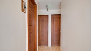 Un pasillo con puertas de madera y un letrero con número.