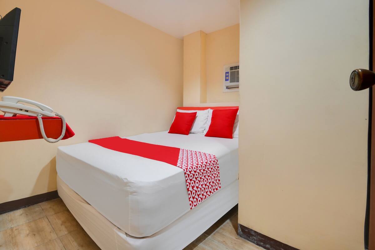 Une chambre d’hôtel équipée d’un lit, d’un téléphone et d’un appareil de climatisation.