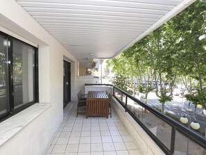 A balcony with a tiled floor, a wooden bench, and a railing. - Modern Apartment with Terrace, A/C, and WiFi in Central Salou (Salou)