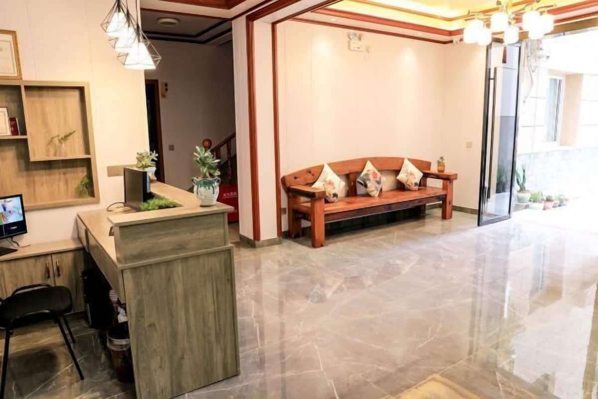 A reception area with a wooden bench, a reception desk, and a television.
