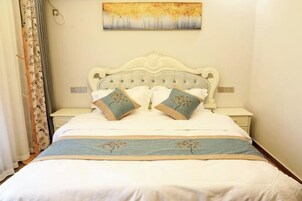 Una cama bien hecha con un cabecero decorativo, una mesita de noche y un cuadro colgado en la pared.