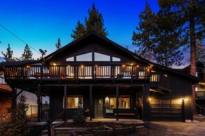 A two-story building with a balcony, a garage, and a well-lit entrance.