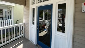 A house with a blue front door, white trim, and a small porch with a white railing. - 1890's Craftsman Home 5BR 4BA, Sleeps 16+ w 6 TVs. (Omaha)