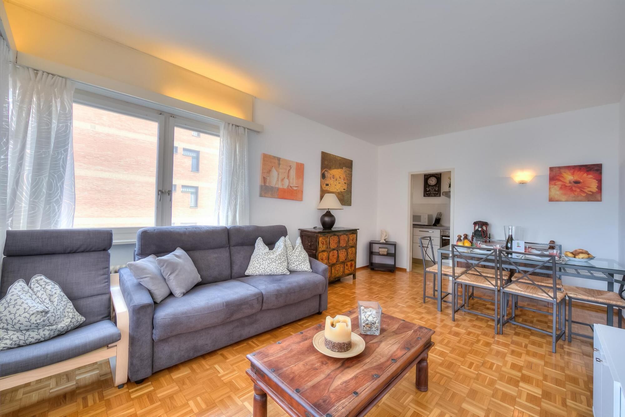 Uma sala de estar com sofá, mesa de centro e área de jantar com mesa e cadeiras.
