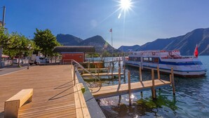 Eine Holzstege, der in einen See führt, mit einem Boot am Ende.