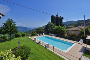A rectangular swimming pool with a tiled deck, surrounded by a low fence. - Villa Medicina in Pescia (Pescia)