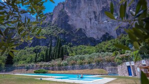 Una piscina amb una paret de pedra i vista a un paisatge de muntanya.