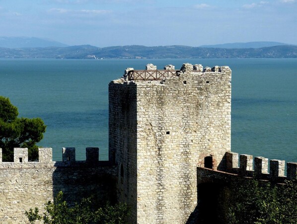 A stone tower with battlements overlooking a body of water.