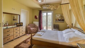 Een slaapkamer met een bed, een dressoir, een stoel en een balkon met uitzicht.