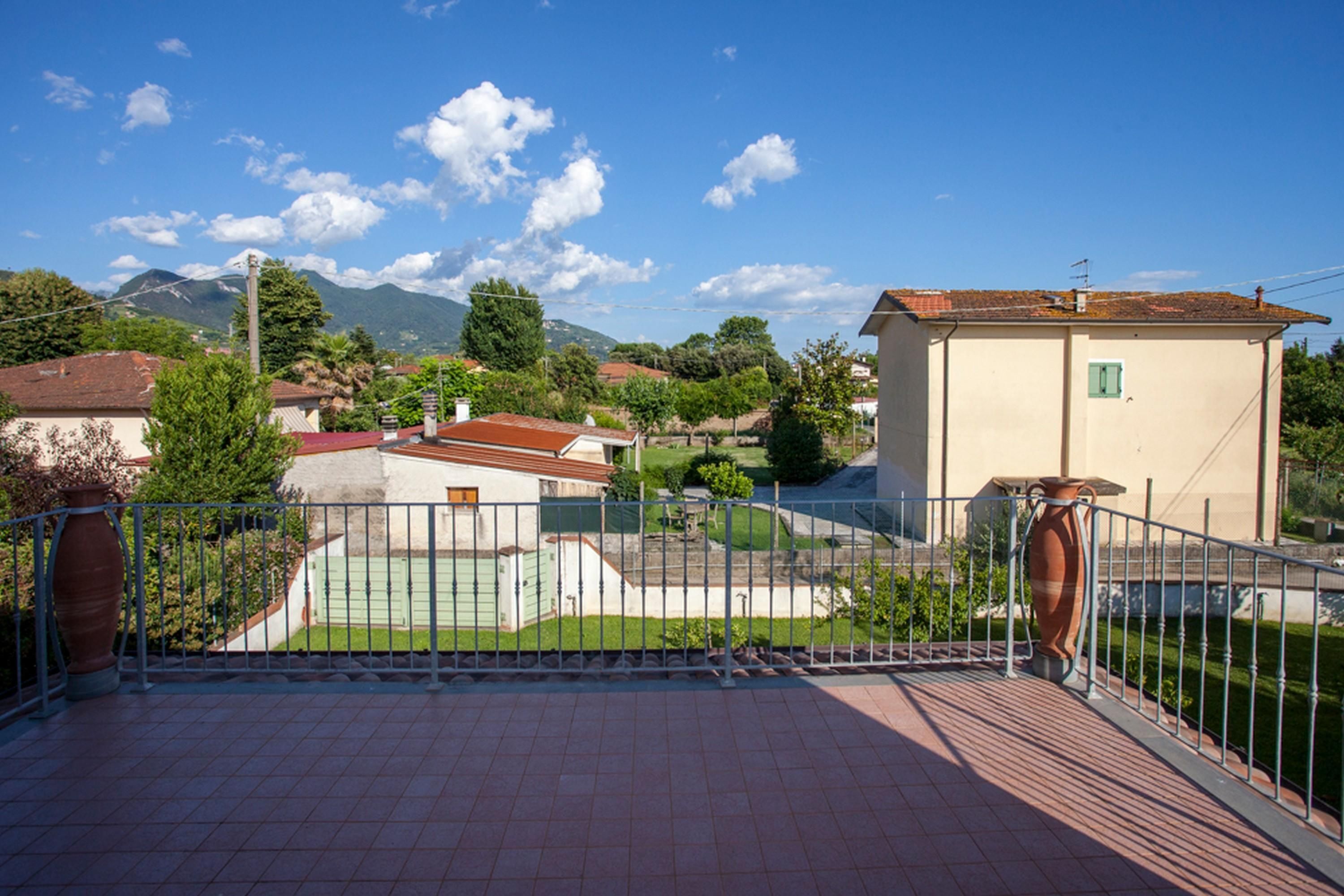 Un quartier résidentiel avec des maisons, un court de tennis et un ciel bleu dégagé.