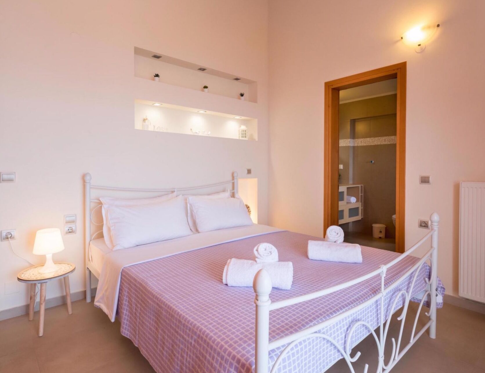 Un dormitorio con cama, mesita de noche y espejo.